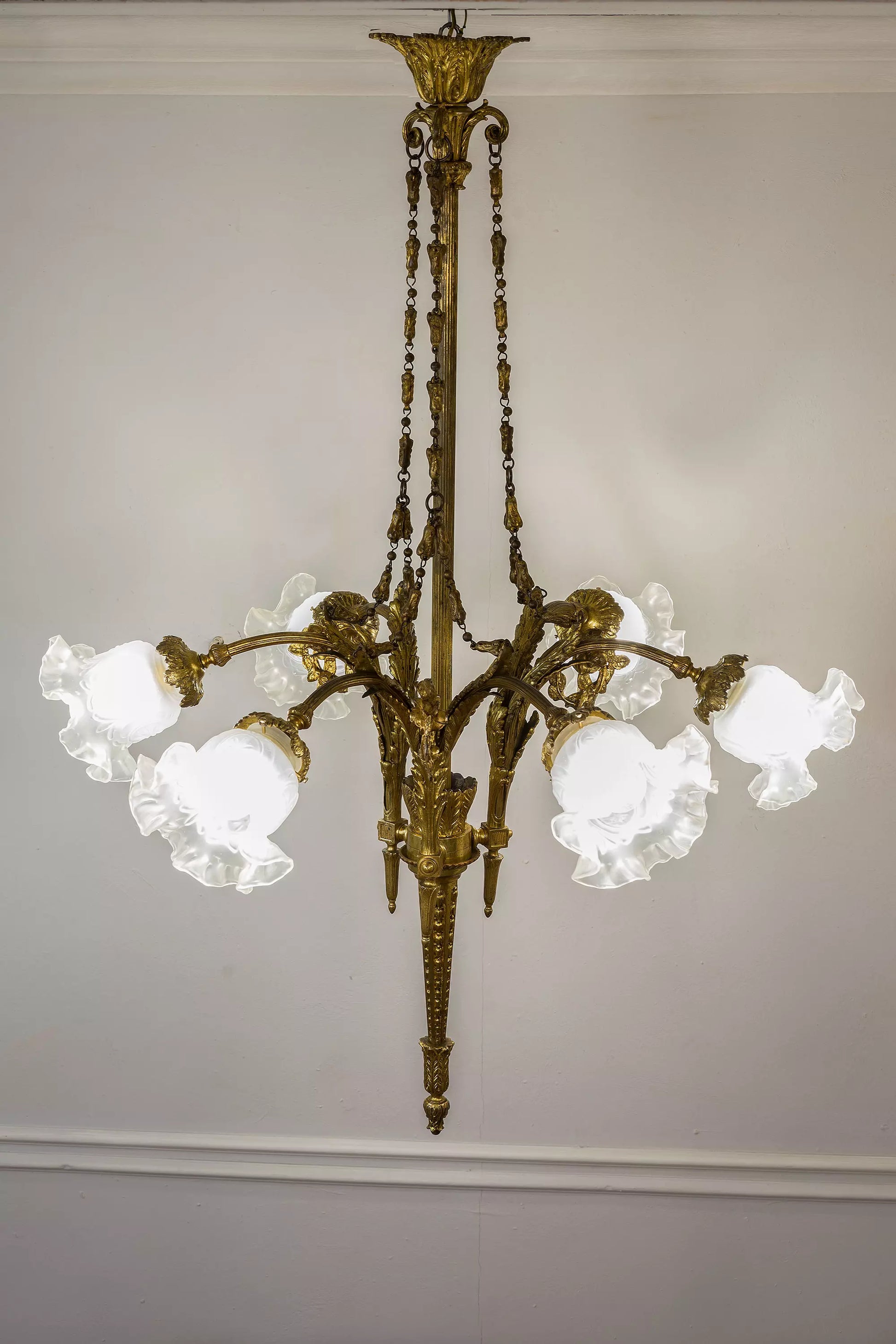 Lampadario vintage in bronzo dorato, un autentico pezzo di illuminazione storica con paralumi in vetro satinato e dettagli cesellati a mano. | Lo Stile Italiano