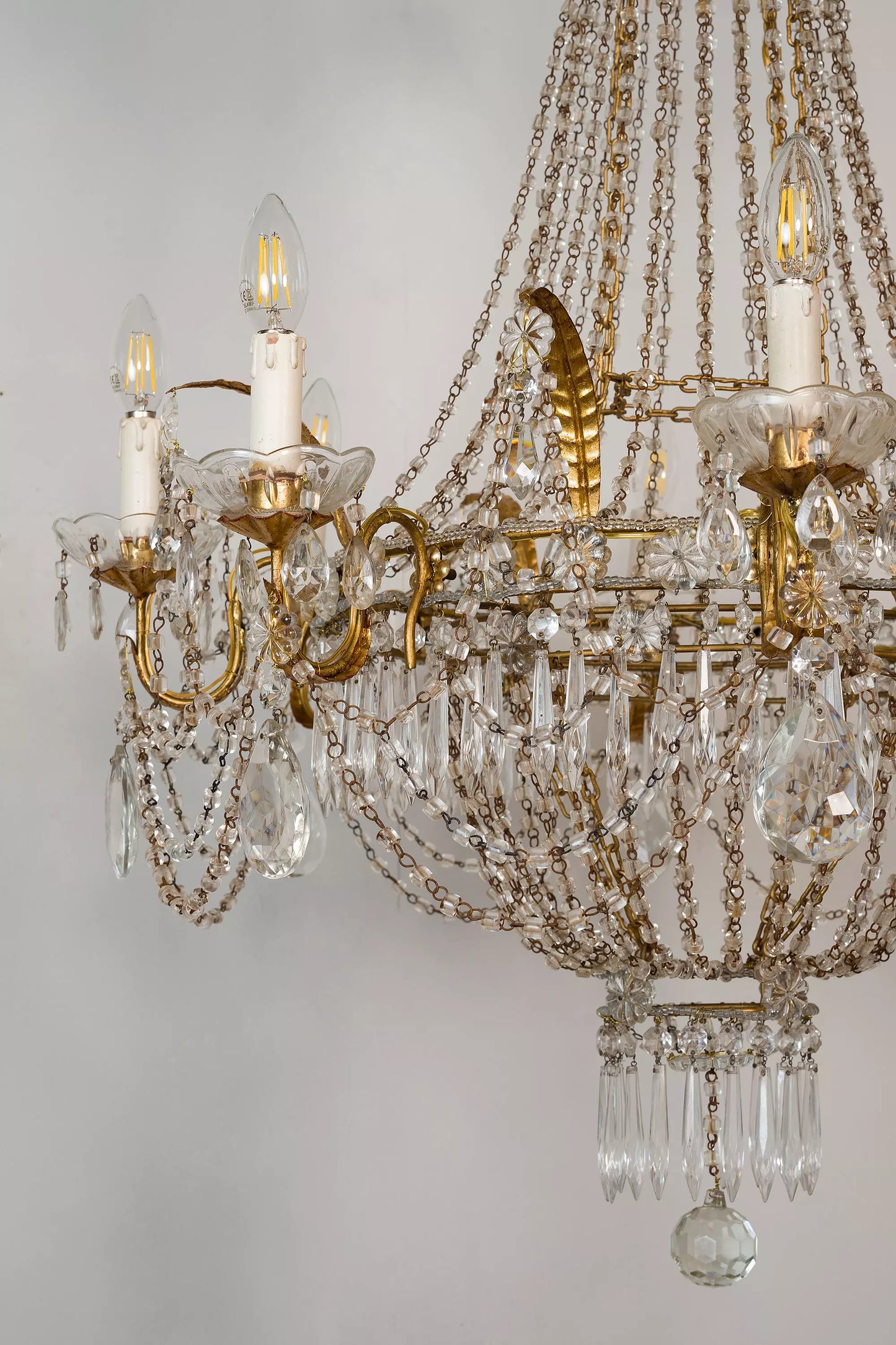 Magnifico lampadario in stile neoclassico, realizzato in metallo dorato con eleganti dettagli in cristallo, ideale per ambienti di lusso.| Lo Stile Italiano