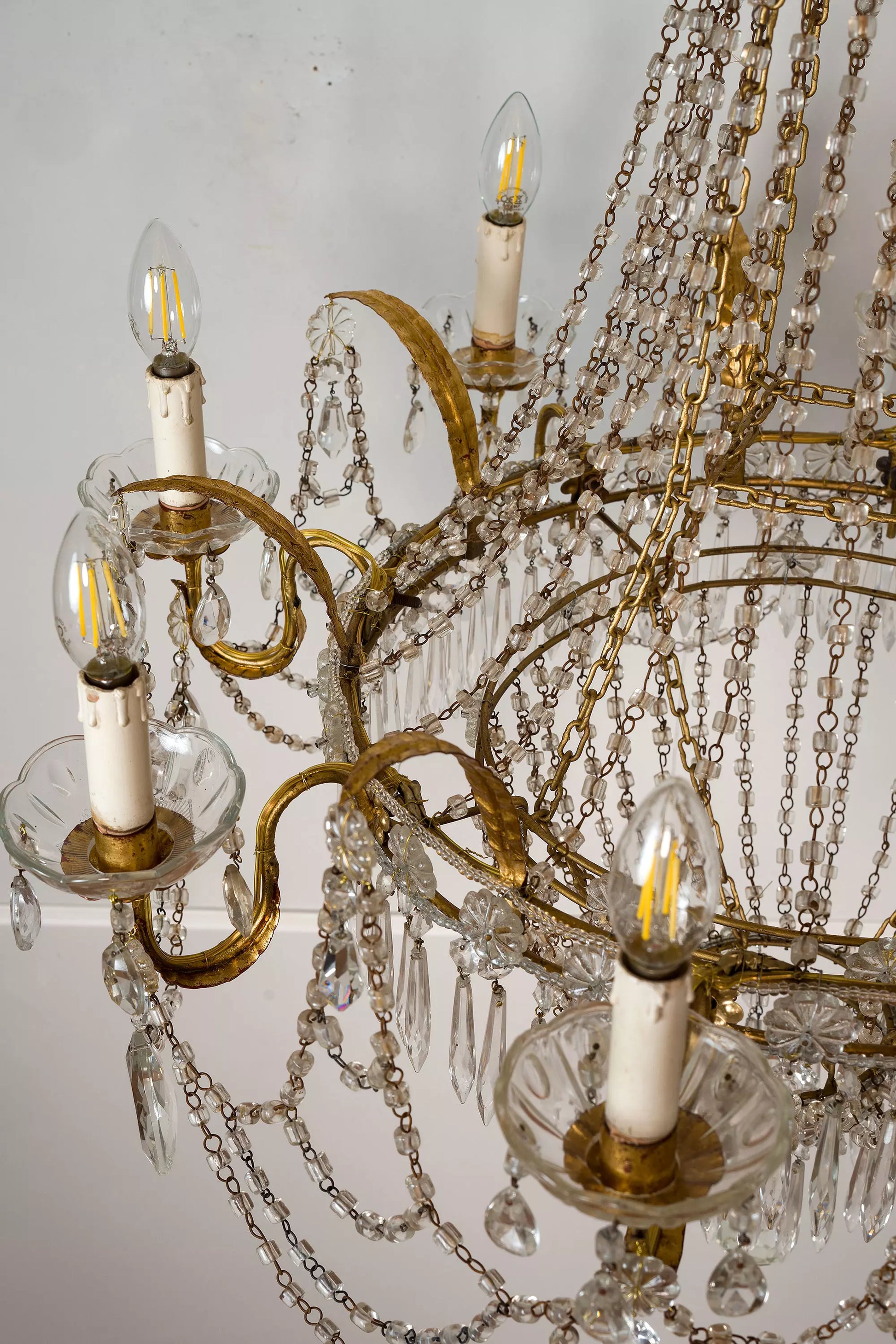 mponente lampadario neoclassico, decorato con foglia oro e cristalli, perfetto per aggiungere un tocco di lusso a qualsiasi ambiente.|Lo Stile Italiano