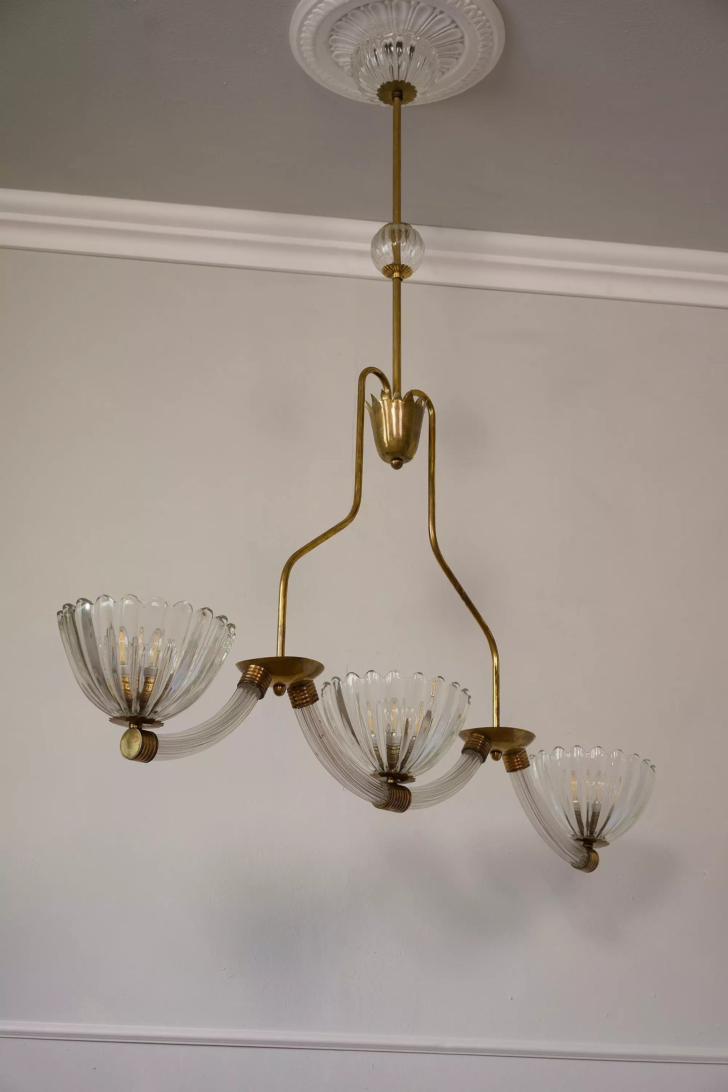 Un lampadario retrò che richiama lo stile vintage degli anni passati, con una combinazione di forme curve e geometriche.